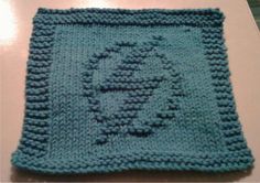 A teal knitted dishcloth featuring a raised power-up design from the video game Metroid.