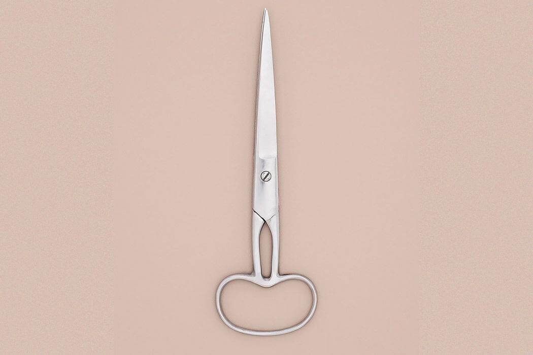 A pair of scissors with a single merged handle instead of two making it impossible to open and close blades.