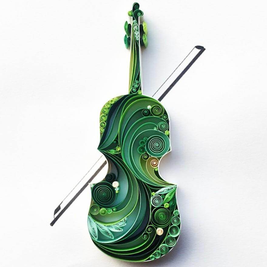 A violin made from intricately quilled green paper with a bow.